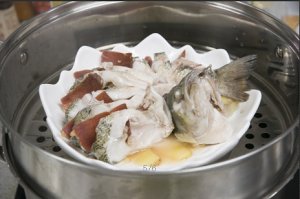 將鱸魚成花狀擺好，將火腿切片放入各縫隙中，放入鍋中隔水蒸12分鐘拿出，撒上蔥花即可。