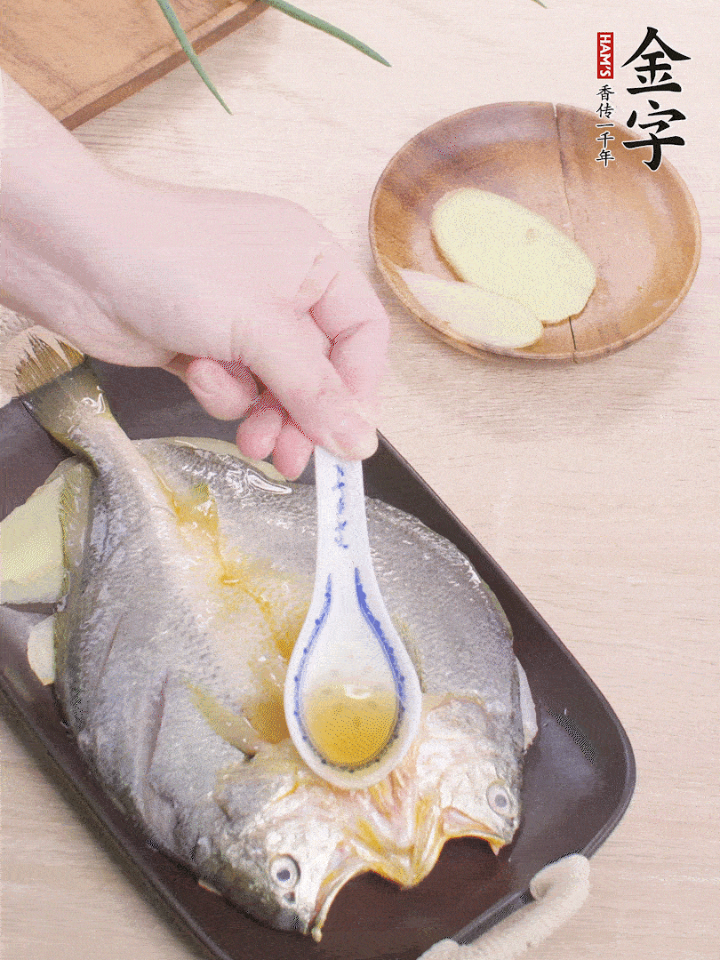 盤(pán)底鋪姜片，放黃魚(yú)，淋2勺料酒。